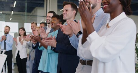 A multicultural group of business people applauds in the office, slowmotion. Concept of recognition and support in the workplace. Professional development. Greetings in the conference hall