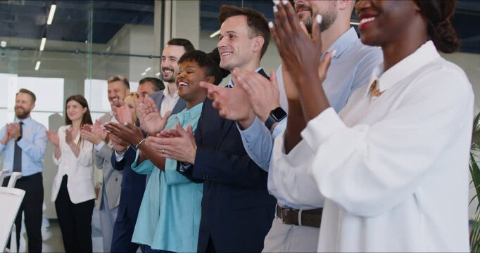 A multicultural group of business people applauds in the office, slowmotion. Concept of recognition and support in the workplace. Professional development. Greetings in the conference hall
