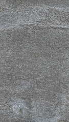 Detailed view of a rough gray concrete surface showcasing its subtle texture and grainy appearance, perfect for background or material reference.