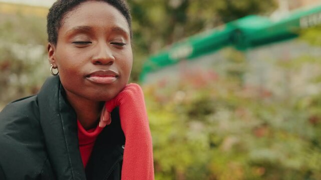 Close up, young woman looking around relaxing on bench on city street