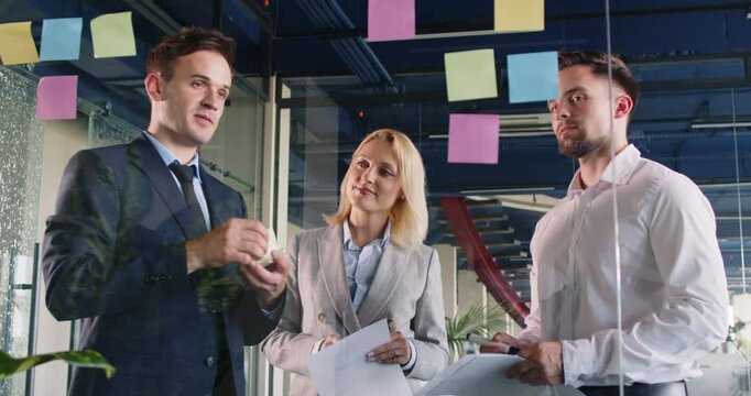 Diverse group of business people collaborates together in the office during a team meeting. Teamwork, partnership, and discussion foster a productive and efficient work environment.