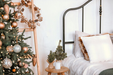 Cozy bedroom decorated for the holidays with a Christmas tree and pine wreath