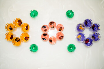 Gel candle in glass isolated on white background. set of colored gel candles. Candle in glass with many colored candles.