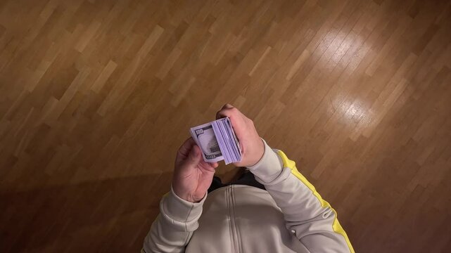 POV first person view Man counting one hundred dollar bills