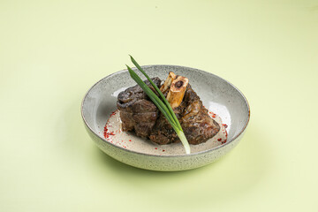 Portion of gourmet baked beef shank with pepper sauce