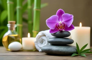 Papier peint photo autocollant Zen Massage spa concept, tranquility and relaxation. A composition of massage stones and an orchid flower in the foreground. Lighted candles and a bottle of oil in the background create a cozy atmosphere  © Lelya