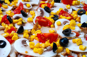 Raw pizza ingredients close-up, tomatoes, mushrooms, ham, corn, olives