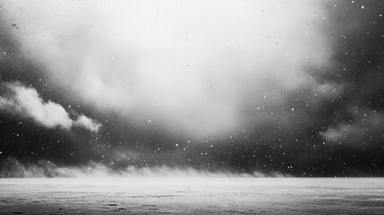 A cold, overcast winter sky with heavy snow falling across an empty frozen lake