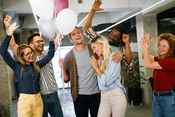 Group portrait of young startup business team celebrating success in the office