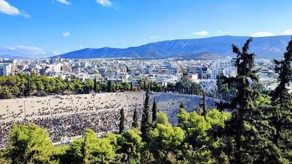 Panoramic view of the Panathenaic Stadium (Kallimarmaro) from atop Ardittos Hill, crowded with spectators attending the 2024 Classic Marathon run.