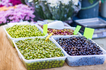 Olives green and black on display at a farmers market outdoors