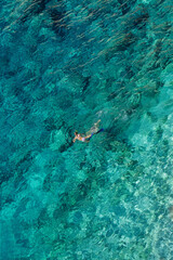 A lone woman swimming in crystal-clear turquoise water, Albania, Ionian Sea, Himare, wild beach, filikuri beach