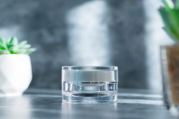 clear cream jar on the grey surface with overlay shadow, use for beauty mockup product