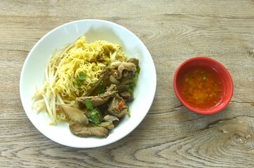 dry boiled yellow egg noodles with braised beef in Chinese  herb on plate dipping spicy chili sauce - Powered by Adobe