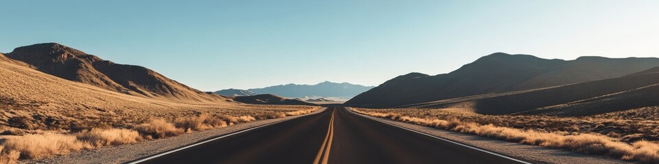 Fototapeta premium winding desert highway through arid mountains, golden hour sunlight, dry brush vegetation, rolling hills landscape, distant mountain ranges, clear blue sky, cinematic wide shot, warm color palette