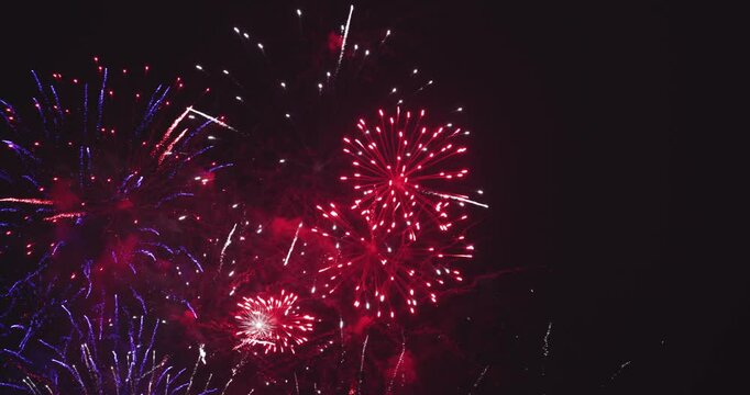 Fireworks in dark sky after celebration. The colors are red, white and blue