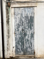 Old shabby white wooden closed door of house