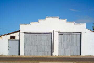 Fototapeta premium Puerta de tablones grises en nave industrial blanca