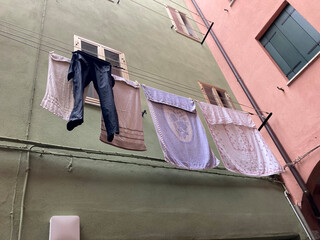 Clothes hanging on rope in backyard of italian town houses