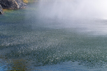water drops sprayed from the fountain on the pond