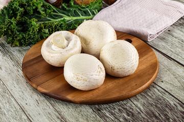 White champignon mushrooms heap over board