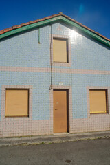 Reflejo del sol en fachada de baldosa de casa de pueblo