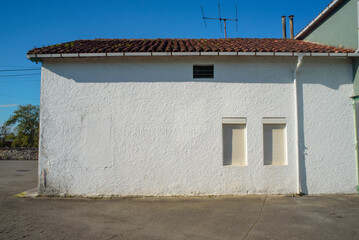 Ventanas en fachada blanca lateral de casa de pueblo