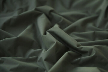 Texture of Dark green military uniform textile cloth with folds