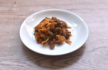 spicy stir fried pickled bamboo shoot and chop bird meat with basil leaf on plate   