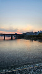 Obraz premium 서울의 한강에서 노을지는 하늘과 불빛이 반짝이는 교량이 있는 도시 경관