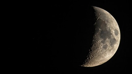 A crescent moon in the night sky, illuminated by the sun, revealing a surface dotted with craters and a dark, smooth sea