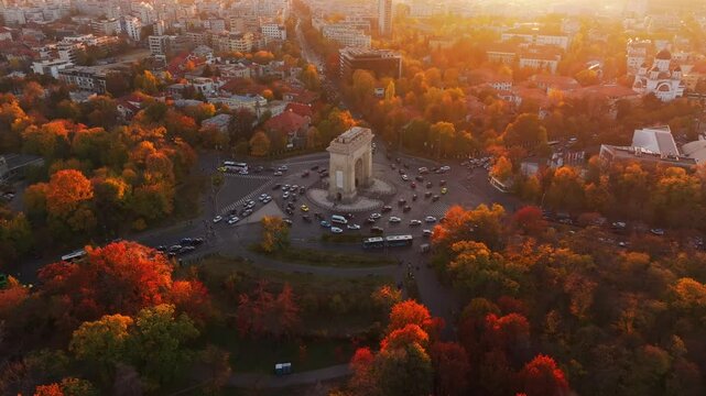 Arch of Triumph in Bucharest, visit Romania. Aerial 4K video with Arch of Triumph historical landmark in Bucharest during a beautiful autumn sunset.