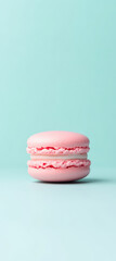 pink macaron on pastel mint background, evoking sweetness and delight