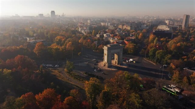 Arch of Triumph in Bucharest, visit Romania. Aerial 4K video with Arch of Triumph historical landmark in Bucharest during a beautiful autumn sunrise.