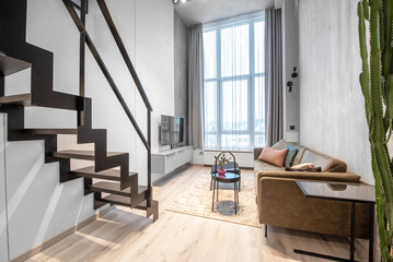 Luxury Loft Style Studio Apartment Stylish Modern Living Room Area, Cozy Bedroom. Minimalistic Modern Interior Without People. Big Sofa, Table, TV, Window. Hardwood Floor and carpet.