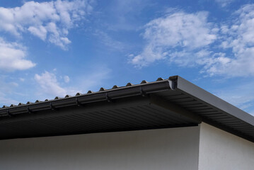 Plastic gutter system on a house against a blue sky