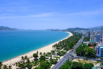 Fototapeta premium a beach with a view of a city and a blue sky