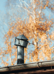 Vintage Metal Chimney Cap on Rustic Roof in Autumn Light