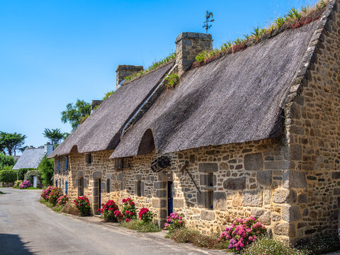 Charming breton Stone Cottages with Thatched Roof and Blue Shutters in the traditional village of Kercanic