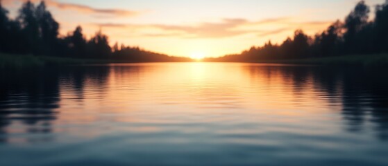 Obraz premium A serene sunset reflects on a calm lake, framed by distant trees, creating a tranquil landscape of warm colors and peaceful water.