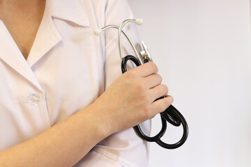 Doctor or nurse with stethoscope in hand. Medicine and health concept. Pediatrician in white coat with stethoscope. Woman, medical and cardiac monitoring instrument, white background. Copy space