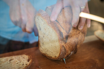 hands of a person cuts a bread