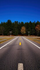 Fototapeta premium a long empty road with a yellow line on the side