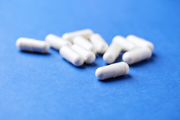 Tyrosine capsules (one of the 20 standard amino acids). A dietary supplement used to improve attention and focus on paper background. Soft focus. Close up.
