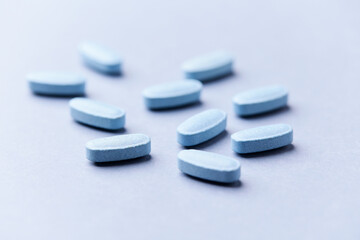 Multivitamin tablets on bright paper background. Close up. Copy space