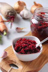 Homemade caviar from beets and carrots in bowl and jar on wooden board