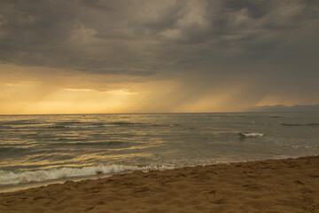 Mare in tempesta. Tramonto con nuvole e una luce di colori. Acqua vento e sole. Paesaggio marino