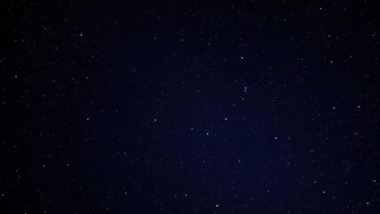 Fototapeta premium Clusters of twinkling stars scatter across the dark expanse of the night sky, shimmering, celestial