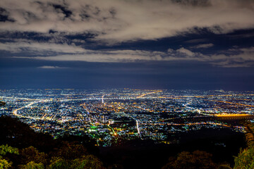 High angle view background from the mountain, showing the lights of apartment buildings, houses, car lights and street lights, the advancement of technology and electricity lighting at night.