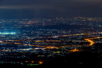 Obraz premium High angle view background from the mountain, showing the lights of apartment buildings, houses, car lights and street lights, the advancement of technology and electricity lighting at night.